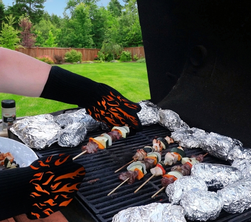 BBQ with foil potatoes and shish kebabs and gloved hands